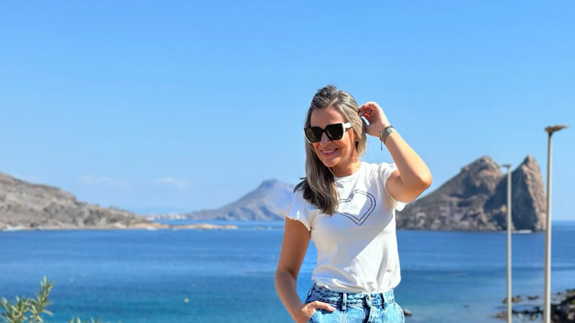Isabel con camiseta blanca junto al mar