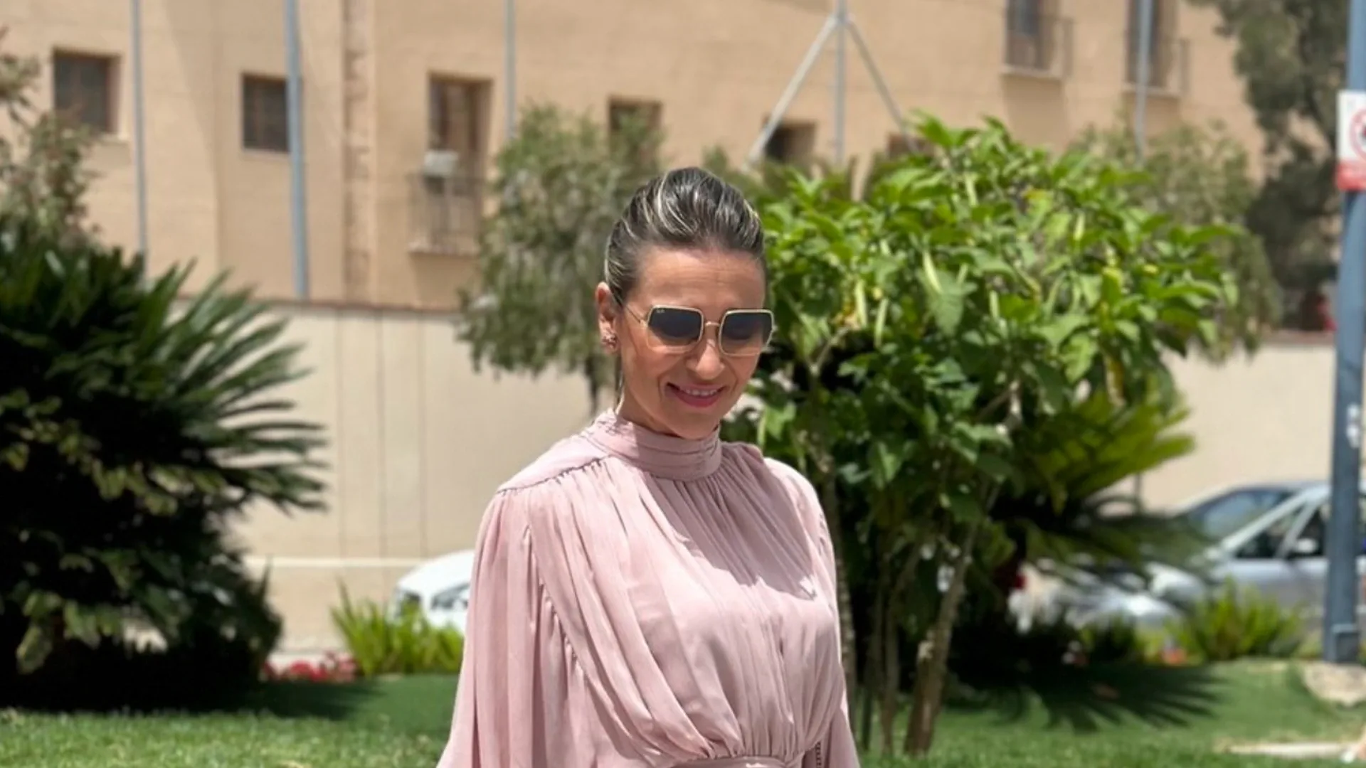 Isabel con blusa rosa en un jardín